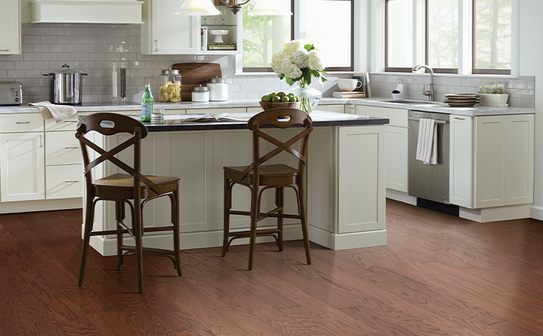 dark hardwood flooring in kitchen with cream cabinets